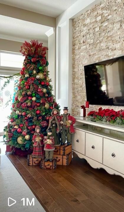 Traditional red, green and gold tree with caroler figurines, viewed one million times